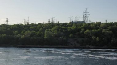 Zaporizhzhia 'daki Dnipro boyunca uzanan elektrik altyapısı. Enerji şebekesi altyapısı doğayla birleşmiş. Nehrin yamaçlarında elektrik desteği.