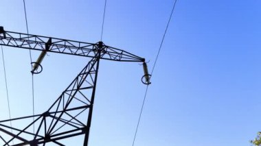 Elektrik mavi gökyüzüne karşı birleşik maddeden yapılmış bir elektrik hattının yakın çekimi. Yayın kulesi ve kablo kamu hizmetleri tarafından elektrik tedariği için mühendisliği gösteriyor