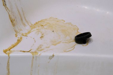 Close-up of a bathtub with noticeable rust and stains. Perfect for articles about bathroom maintenance, rust removal, or promoting household cleaning products. clipart