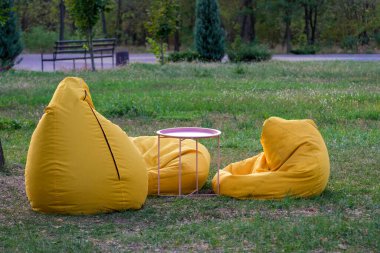 Küçük bir masa ile birlikte parlak sarı fasulye torbaları güzel bir konforlu ve davetkar bir oturma alanı oluşturur.