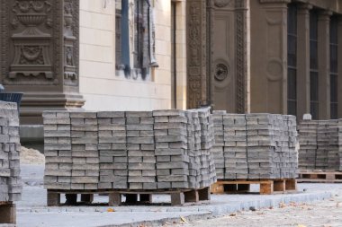 Sağlam ahşap paletler üzerinde sağlam beton kaldırımlar düzgünce düzenlenmiş bir yığın modern kentsel inşaatlarda kullanılan yüksek kaliteli materyalleri gösteriyor, hem estetik çekiciliği hem de dayanıklılığı artırıyor