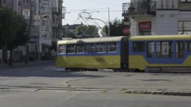 Kyiv, Ukrayna - 15 Temmuz 2024: Güneşli bir günde, canlı sarı bir tramvay bir kavşakta ustalıkla yol alır.