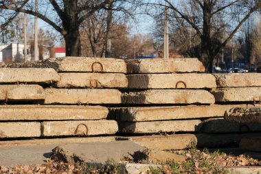 Yığılmış beton levhalar daha önce kullanılmış yapı malzemeleridir. Belediye kanalizasyon sisteminin onarımı için gerekli malzemeler şehrin caddesinde bulunmaktadır..