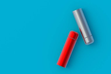 Mavi arka planda termoslar. Metalik termo mataralar. Mesaj için yer var. Üst Manzara. 3d oluşturma