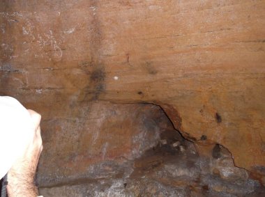 Kırmızı delikli eski taş duvar.