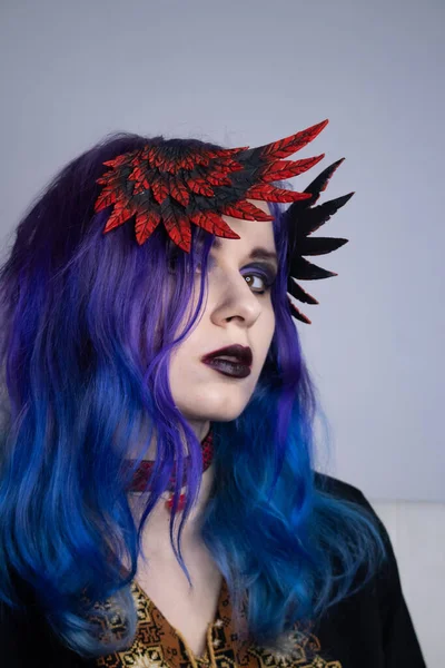 A woman with bright purple hair and clipped wings. Model for advertising hair dye. Purple hair. Colored hair, people with tattoos, informals. Gothic girl with purple hair and a choker around her neck. Girl with valkyrie wings cosplay.