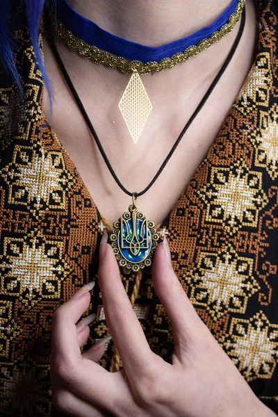 Vyshyvanka on her shoulders. Neck with jewelry. Slavic Ukrainian embroidery and decorations. Slavic national dress.
