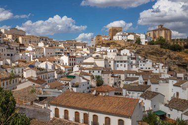 Exposure of Setenil de las Bodegas famous for its dwellings built into rock overhangs above the Rio Guadalporcn, Cadiz, Spain