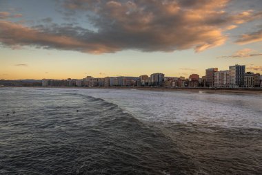 İspanya, Sunset 'te sörf yapmak için dalgalı güzel bir sahil şeridinin Gijon rıhtımından....