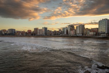 İspanya, Sunset 'te sörf yapmak için dalgalı güzel bir sahil şeridinin Gijon rıhtımından....