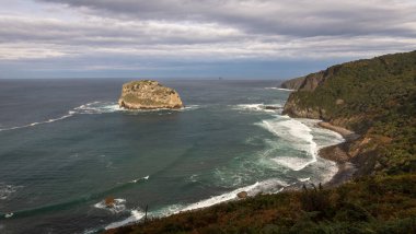 San Juan de Gaztelugatxe adası ve kıyı kasabaları Bakio ve Bermeo arasında yer alan inziva yerinin kıyıya taş bir köprü ve 241 basamaklı bir merdiven, İspanya 'nın Bask sahili,.