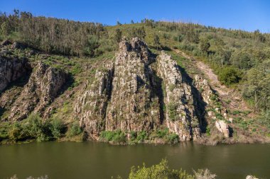 Mondego kıyısında Penacova 'nın yanındaki manzarayı gösteren bu doğal anıtın ortaya çıkışı, Livraria do Mondego zamanın 400 milyon yılı aşkın bir süredir oyduğu bir anıttır..