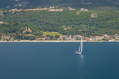 Güneşli bir günde Kotor Körfezi 'nin deniz girişini, güzel kıyı manzaralarını ve küçük köylerini gösteren bir gezi gemisinden manzara teşhir etmek..