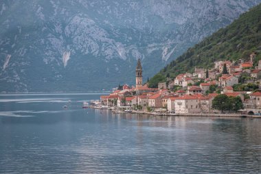 Gün batımında bir yolcu gemisinden çekilen manzara Kotor Körfezi 'nin deniz girişini ve güzel kıyı manzaralarını ve küçük köyleri gösteriyor..