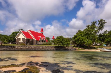 Mauritius 'un en ünlü kiliselerinden biri olan Notre Dame Auxiliatrice Kilisesi, parlak turkuaz deniz ve gök mavisi gökyüzüne karşı canlı kırmızı çatısıyla ünlü Roma Katolik Kilisesi' dir. 