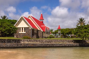 Mauritius 'un en ünlü kiliselerinden biri olan Notre Dame Auxiliatrice Kilisesi, parlak turkuaz deniz ve gök mavisi gökyüzüne karşı canlı kırmızı çatısıyla ünlü Roma Katolik Kilisesi' dir. 