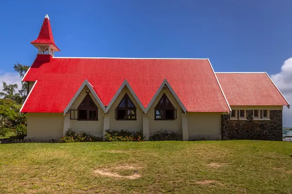 stock image Exposure of on of the most renowned churches in Mauritius is the Notre Dame Auxiliatrice Chapel, a Roman Catholic Church famous for its vivid red roof against the bright turquoise sea and azure sky 