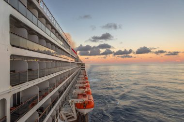 Şafak vakti, denizde muhteşem okyanus gökyüzünü gösterirken klasik bir gezi gemisinden yapılan pozlama.