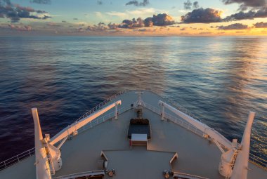 Şafak vakti, denizde muhteşem okyanus gökyüzünü gösterirken klasik bir gezi gemisinden yapılan pozlama.