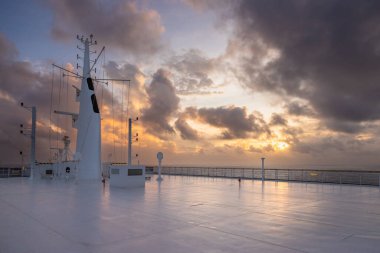 Şafak vakti, denizde muhteşem okyanus gökyüzünü gösterirken klasik bir gezi gemisinden yapılan pozlama.