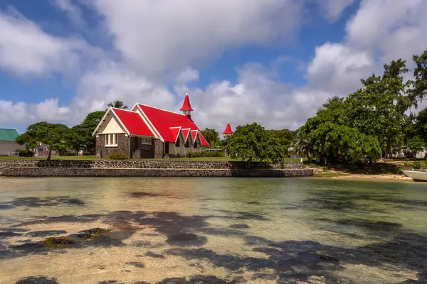 Mauritius 'un en ünlü kiliselerinden biri olan Notre Dame Auxiliatrice Kilisesi, parlak turkuaz deniz ve gök mavisi gökyüzüne karşı canlı kırmızı çatısıyla ünlü Roma Katolik Kilisesi' dir.