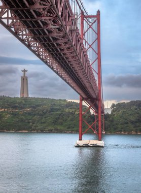 25 Nisan Köprüsü ve Tagus Nehri 'nin doğuşunda Lizbon' a varırken bir gemi tarafından yapılan panoramik sergilenme sol kıyıda Lizbon ve Portekiz Kralı Lizbon Sığınağı ile birlikte gerçekleşti.