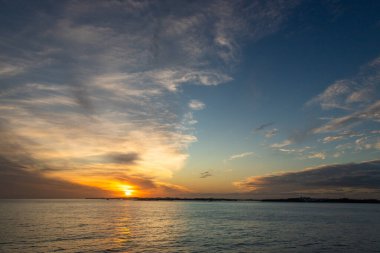 Gün batımında Karayip Denizi 'nin tropikal sularında sürüklenen dramatik bir bulut kümesi gün ışığının son dakikalarında aydınlanır..