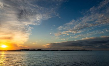 Gün batımında Karayip Denizi 'nin tropikal sularında sürüklenen dramatik bir bulut kümesi gün ışığının son dakikalarında aydınlanır..