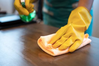 Evdeki mutfak masasını temizleyen kadının bir parçası. Genç kız temizlikçi, temizlikçi, ev işleri ya da ev işleri.