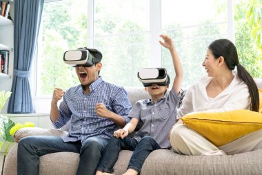 Küçük bir aile evde sanal gerçeklik ve oyun konseptiyle eğleniyor..