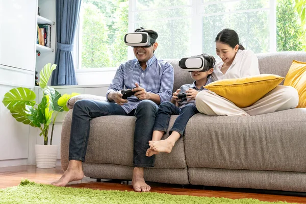 Small family having fun with vr headset at home - Virtual reality and gaming concept.