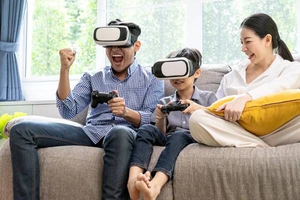 Small family having fun with vr headset at home - Virtual reality and gaming concept.