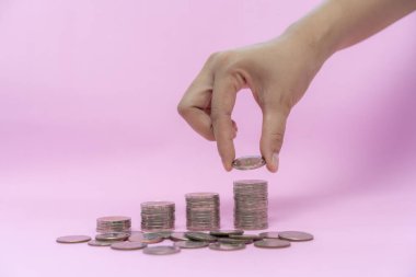 Pembe arka planda para yığını, tasarruf konsepti
