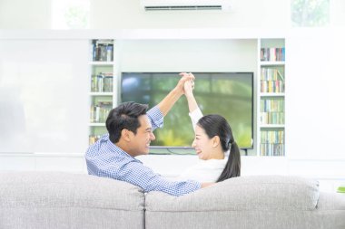 Evde oturup televizyon izleyen genç çiftlerin arkası..