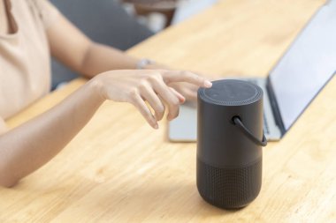 Modern Teknoloji Kavramı. Genç bayan evde taşınabilir hoparlör kullanıyor..