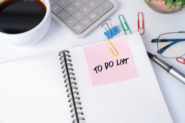 Not defterinde pembe etiket olan ofis masası..