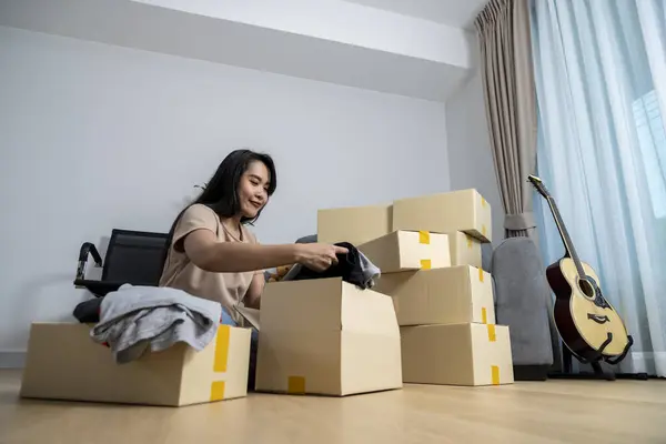 The young woman is packing her belongings in preparation for moving