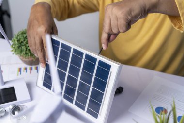 Adam ampullere elektrik sağlamak için güneş paneli icat ediyor..