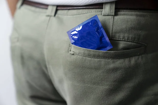 The man has a condom in his pants pocket.