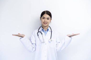 Beyaz önlüklü bir kadın doktor reklam metni için arka planda boş bir boşlukla poz veriyor..