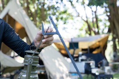 Kamp yaparken bir kampçı fener asıyor.