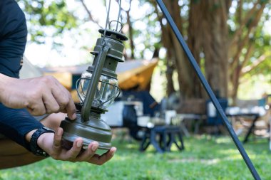 Kamp yaparken bir kampçı fener asıyor.