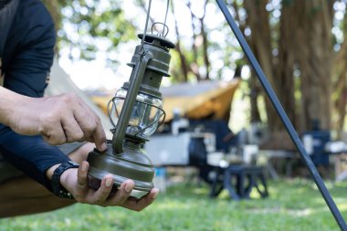 Kamp yaparken bir kampçı fener asıyor.