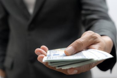 Man hand with a stack of hundred US dollars bills
