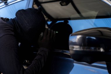 Arabadan değerli şeyler çalan bir hırsız.