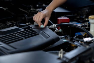 The young woman is inspecting the engine.