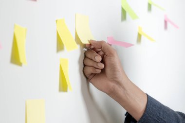 A young businessman with sticky notes on the wall