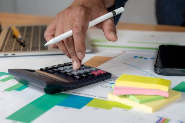 Hesap makinesi, kağıt ve mali belgeler kullanarak harcamalar hesaplanıyor