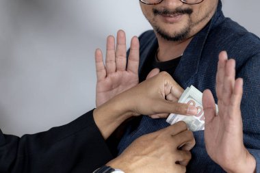 Rüşveti reddeden genç bir işadamı, iş hayatında dürüstlüğü ve etik davranışı sembolize ediyor.