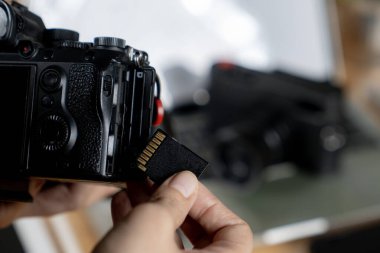 Serbest yaşam, fotoğraf makinesinden bilgisayara fotoğraf kopyalayan mutlu genç bir fotoğrafçı.